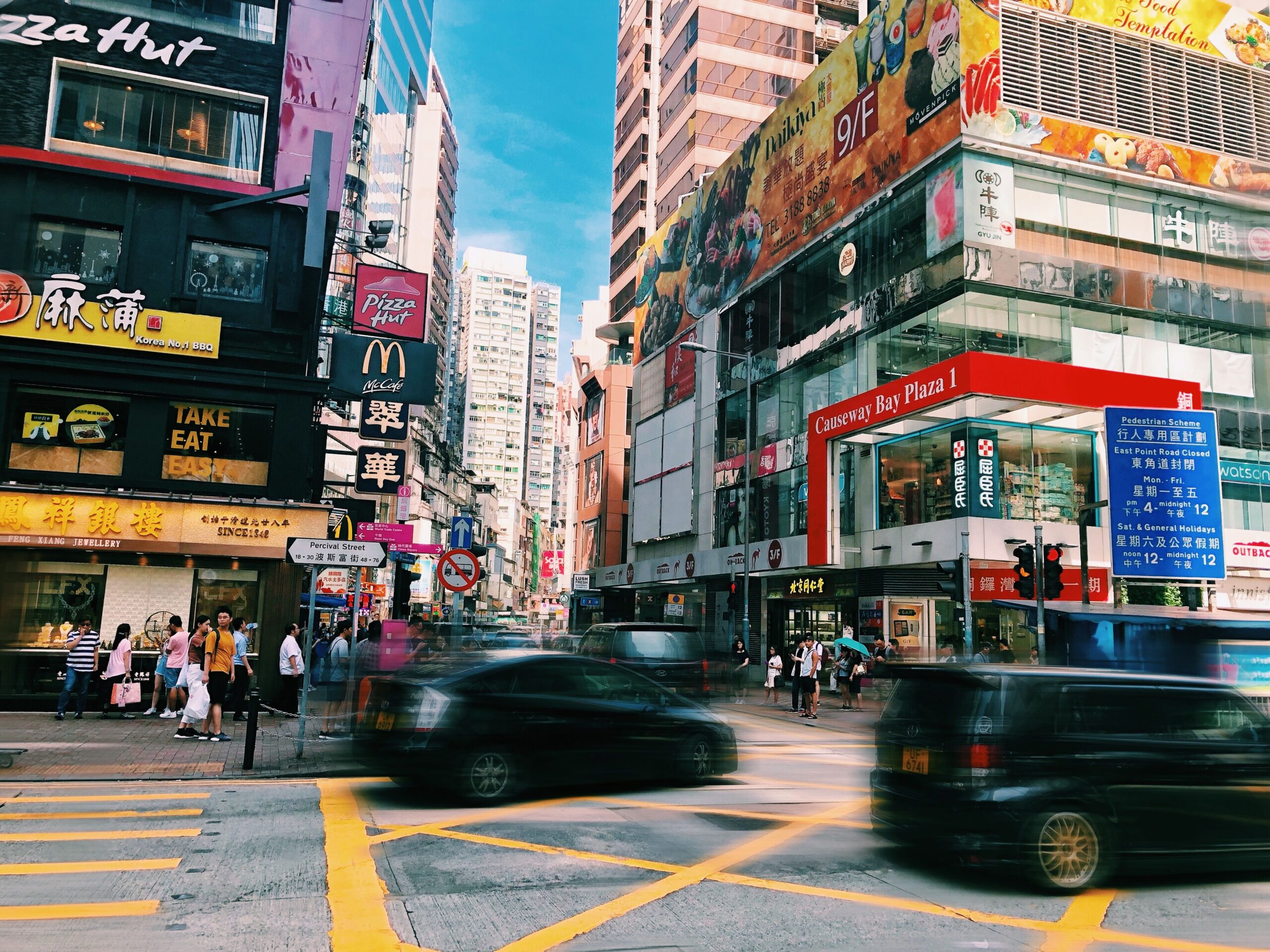 Vibrant street scene in Causeway Bay, Hong Kong featuring busy pedestrian traffic and colorful signage.